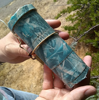 Beige-skinned hands holding a blue cylindrical container