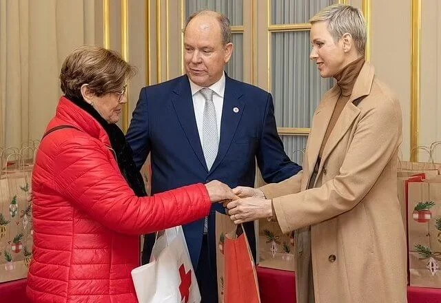 Princess Charlene wore an Emotion belted camel hair trench coat by Akris. Akris cashmere silk jersey top and Flavin wool flannel pants