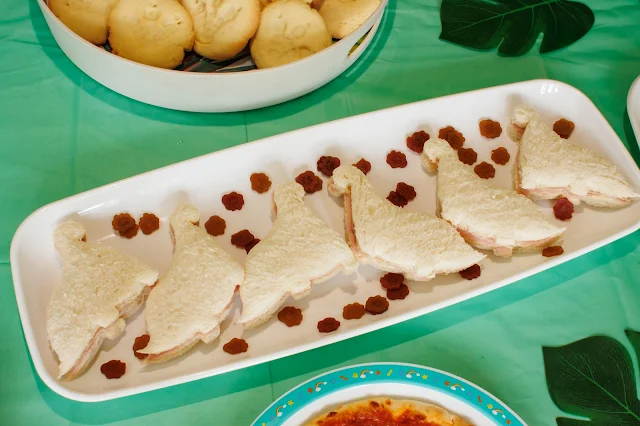 close up of dinosaur shaped ham sandwiches surrounded by Bears paws snacks