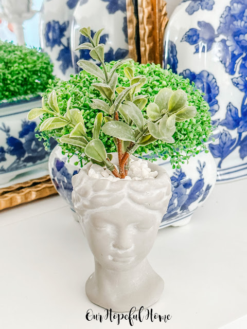 Grecian head planter filled with faux boxwood