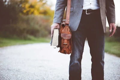 a man in a suit and tie holding a book, a man wearing a backpack, bible verses about leadership