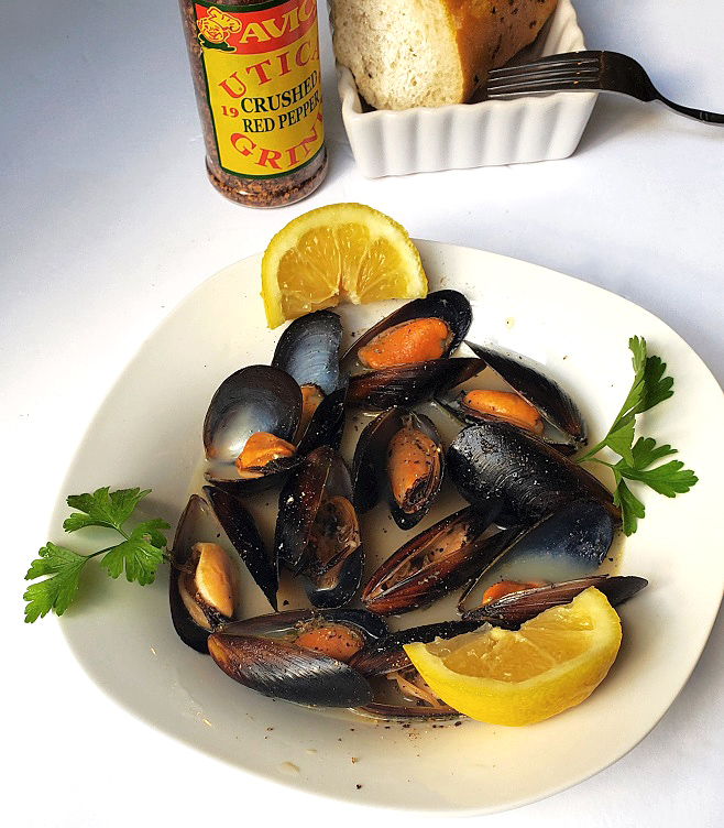 garlic wine butter mussels in a white dish cooked