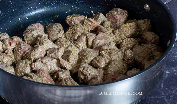 Marinated beef frying in a pan to add to curry