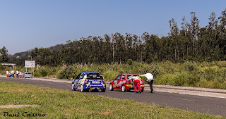 Piloto y copiloto empujan su vehículo para llegar hasta el punto de control en el paddock del rallye