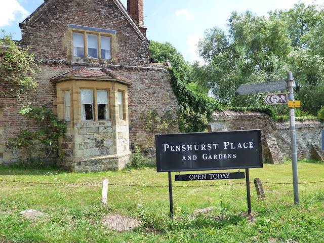 Black sign with white writing reading 'Penshurst Place and Gardens' located in front of the gate house near Tonbridge in Kent