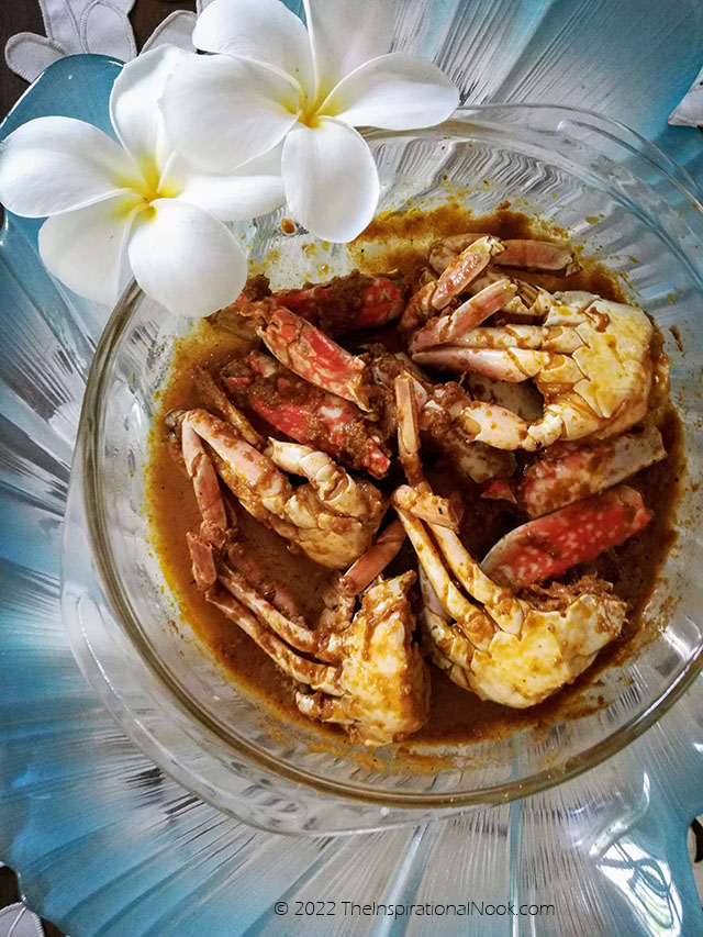 Crabs in a blue dish with white frangipane flowers