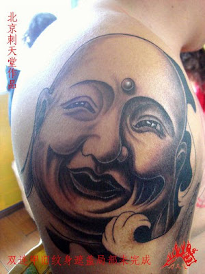 smiling Buddha tattoo on the arm