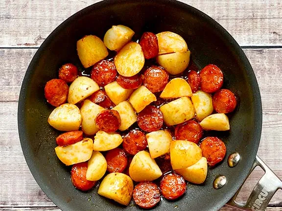 Potatoes and chorizo cooking in a frying pan.