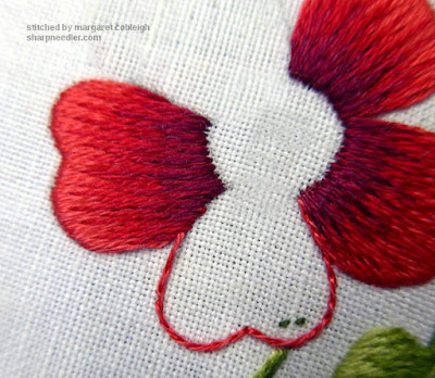 Split stitching the outline of a needlepainted rose petal.