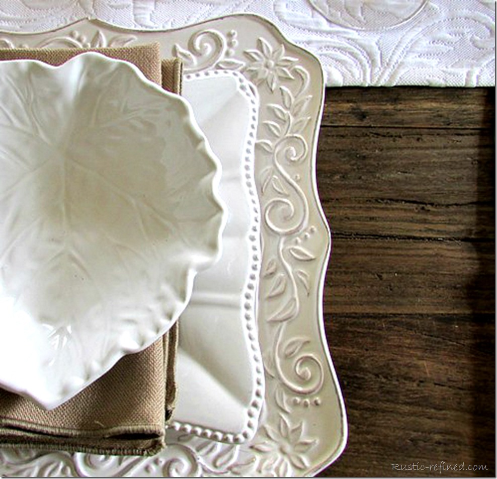 Square white dishes on a barn wood dining table