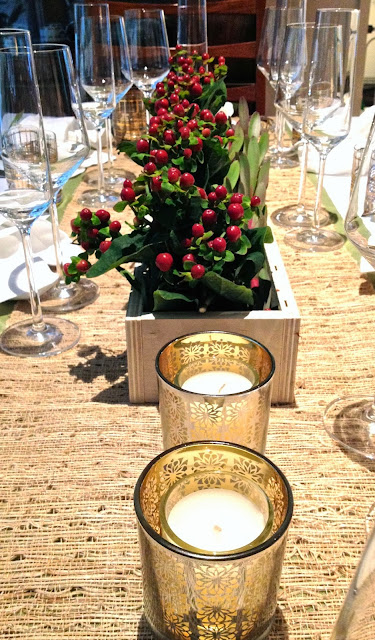 DIY centerpiece with winter berries and gold votive candles