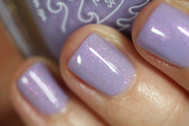 pastel lilac nail polish with green and pink shimmer shown on white person's hands