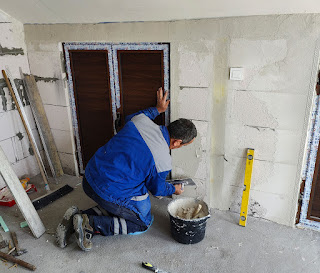 Bekir is plastering the other side of the room