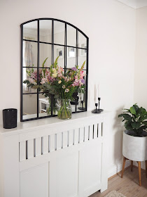 How to style a radiator cover in your living room using accessories and items you already own including artificial greenery, candles and flowers.