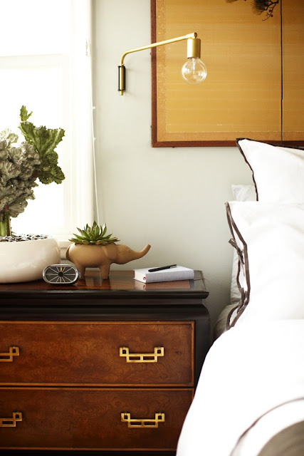 Bedroom after makeover white bedding with brown trim brass and gold accessories wood nightstand succulents