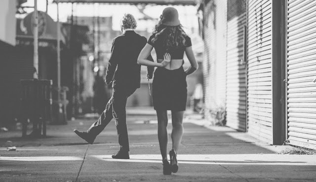 A fashionable couple wanders the street