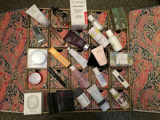 A photo of the contents of all of the Liberty London Beauty Advent calendar on top of the calendar 