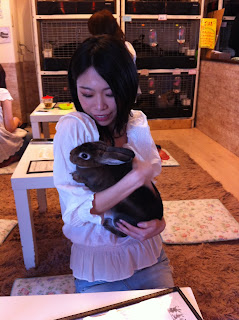 A girl holding a rabbit at a rabbit cafe