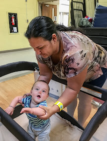 Katrina places her 9-month-old son, Malachi, in a pack-and-play crib. Malachi fell off his cot when he was sleeping and bumped his nose. The family is staying in a hurricane shelter in San Antonio, Texas.