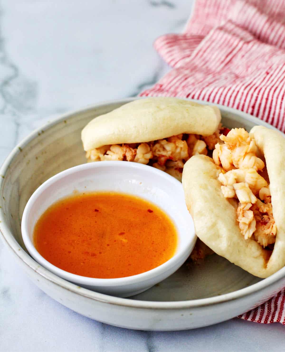 Spicy Lobster Bao with butter dipping sauce in the bowl.