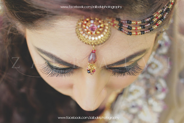 A headshot of a bride, with a tikka on her head