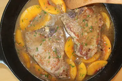 Skillet peaches and cream pork chops cooking.