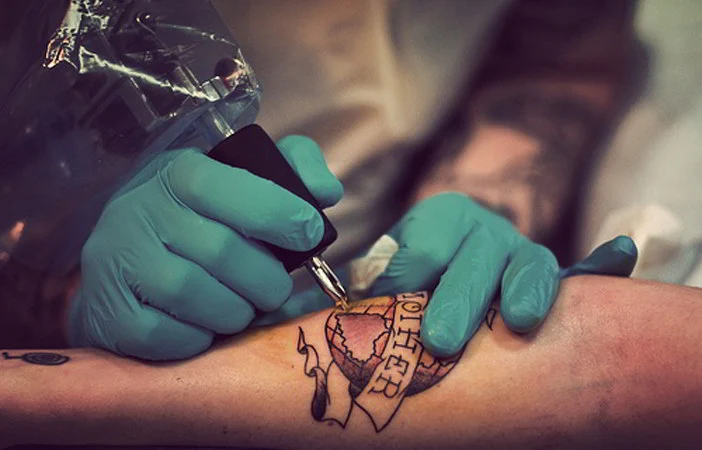 Un tatuador tatuando una bola del mundo