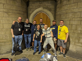 A group of eight people posing for a photo in the Warhammer World events hall