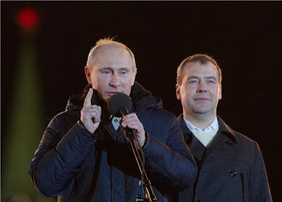 Putin speaks at a demonstration, with Medvedev