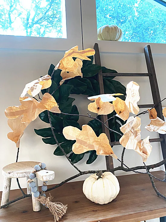 paper leaves on a branch with a ladder and wreath