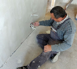 Scraping over-spilled plaster from a junction box