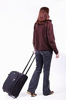 Photo of a woman wheeling a small suitcase