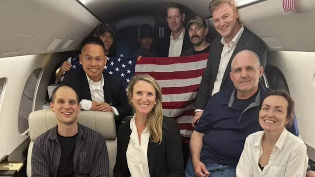 Cette image publiée par la Maison Blanche montre Evan Gershkovich, à gauche, Alsu Kurmasheva, à droite, et Paul Whelan, deuxième à partir de la droite, et d'autres à bord d'un avion après leur libération de captivité russe.