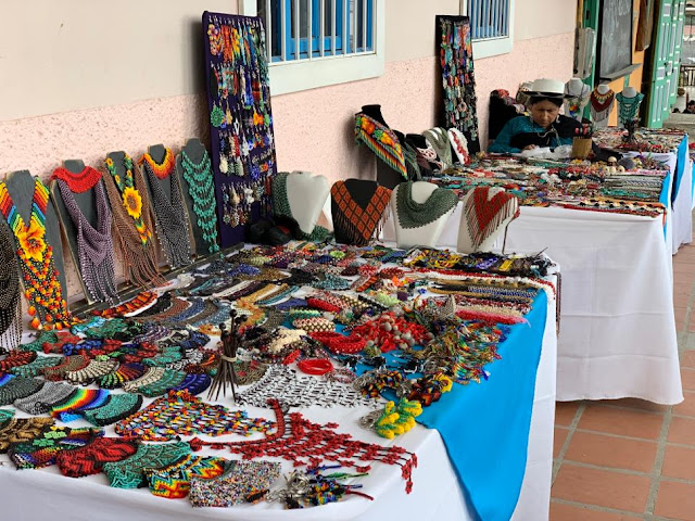 Three of the tables at the Saraguro market. Note earrings and other items available in addition to necklaces. Loja Ecuador