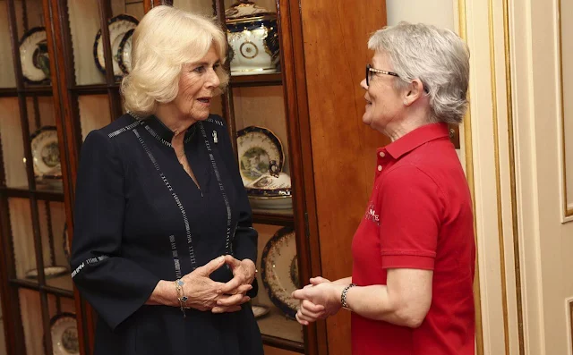 Queen Camilla wore a navy midi dress. Queen Camilla met with Tracy Edwards MBE