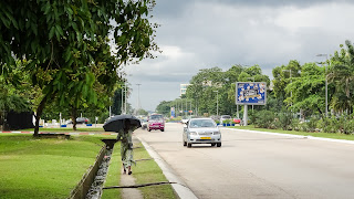 People in Gabon wearing umbrellas to cover from UV