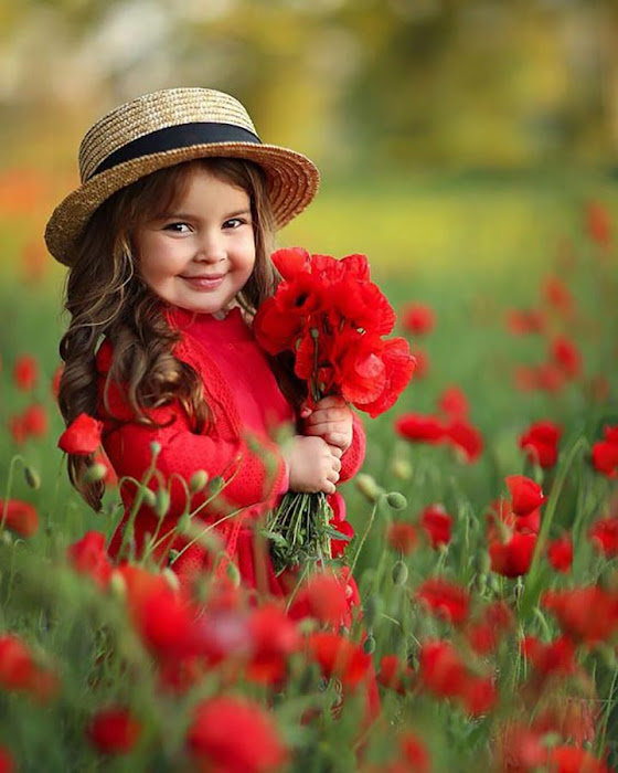 فتاة صغيرة تحمل الورود الحمراء