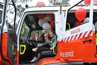 Girls sitting in fire tanker with red and white balloons