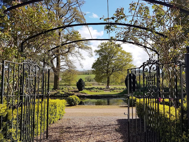 View of the garden through a wrought iron arch and gates