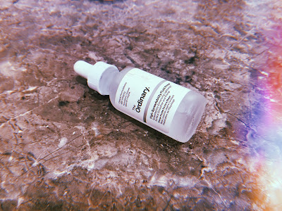 a pipette bottle of primer lying on its side on a marble surface