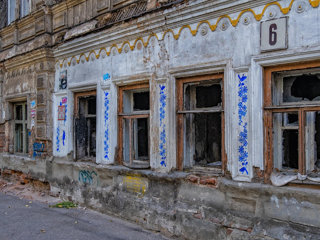 Арт в стиле раскраски фаянсовой посуды на фасаде заброшенного здания