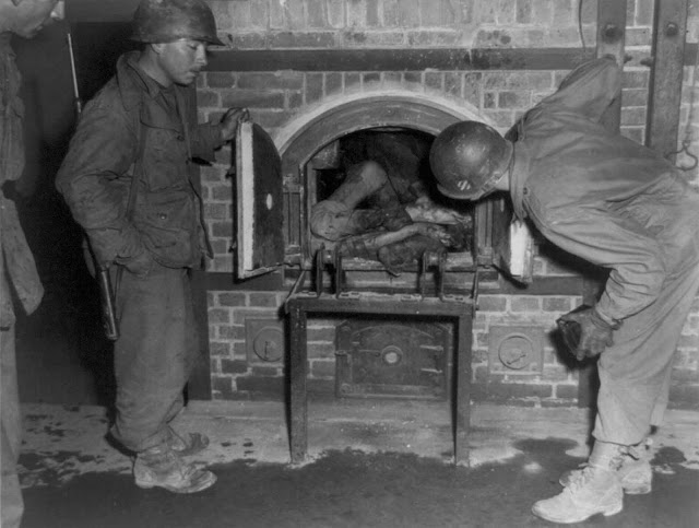 Three U.S. soldiers look at bodies stuffed into an oven in a crematorium in April of 1945. Photo taken in an unidentified concentration camp in Germany, at time of liberation by U.S. Army.