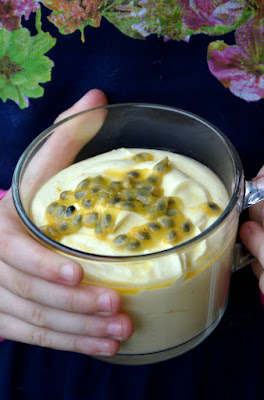 Hellgelbe Topfencreme mit Safran in einem Glas, mit frischer Maracuja dekoriert.