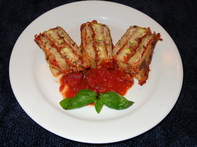 PORTIONS: 12 INGREDIENTS 1 Large breaded eggplant in slices 6 breaded zucchinis in slices Meat sauce Tomato sauce 1 lb. ricotta cheese 1½ lb. shredded mozzarella cheese ½ cup grated roman, parmesan or pecorino cheese INGREDIENTS TO BREAD THE VEGETABLES 1 large eggplant cut in thin slices 6 zucchinis cut in thin slices 1 cup all-purpose flour  4 beaten eggs 2 cups panko bread crumbs 2 cups regular bread crumbs METHOD Season the flour and eggs with a bit of salt. Mix panko and regular bread crumbs. Dip the eggplant and zucchini slices in flour, eggs, breadcrumbs and place them in a baking sheet pan. Preheat the oven in low broil. Brown the eggplant and zucchini. MEAT SAUCE 14 oz. / 397g ground beef 1 tbsp. olive oil 3 garlic cloves, minced 1 cup small diced onions ½ cup small diced carrots ½ cup small diced celery 1 tsp. salt ¼ tsp. pepper 1 tbsp. capers 1 tbsp. pitted green olives, diced 1 tbsp. fresh basil leaves cut in thin strips ½ tbsp. fresh oregano leaves 5 cups chunky tomato sauce METHOD Heat a frying pan with olive oil and brown the ground beef. Add garlic, onions and slightly brown them. Add the carrots, celery, salt, pepper and cook for a couple minutes. Incorporate the capers, olives, basil leaves and tomato sauce. Mix and heat up.  RICOTTA CHEESE ¼ tsp. salt ¼ tsp. onion powder ¼ tsp. garlic powder 1 tbsp. chopped fresh basil leaves METHOD Mix the ricotta cheese with the rest of the ingredients. ASSEMBLING THE LASAGNA Spread a layer of tomato sauce in a baking dish Using a spatula spread the ricotta cheese along the eggplant and zucchini baked slices. Place a layer of eggplant on top the tomato sauce. Add a thin layer of meat sauce and on top shredded mozzarella with grated cheese. Place on top a layer of zucchini, meat sauce, shredded mozzarella and grated cheese. Finish the lasagna with another layer of baked vegetables, meat sauce, shredded mozzarella and grated cheese. Bake it a 400°F / 204°C until the top is golden brown. Let it rest for a few minutes before cutting.