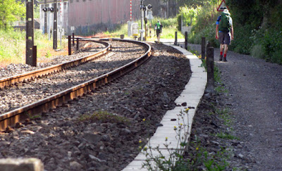 peregrino de Santiago caminhando ao lado da linha do trem