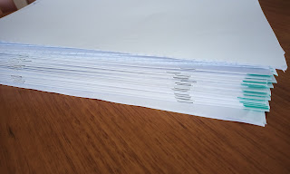 A pile of exam papers needing to be marked