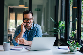 A man on the phone smiling | Collection agency Michigan