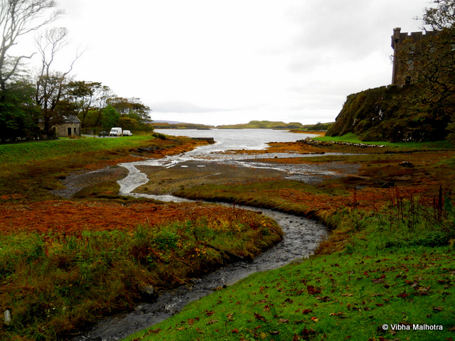 A visit to the Dunvegan Castle and Grounds, Scotland. A bonus view from the castle's grounds...to keep you motivated to visit Scotland. :). Dunvegan Castle is the situated at a distance of about a mile and a half to the North of Dunvegan on the Isle of Skye and it is the seat of MacLeod of MacLeod, the Chief of MacLeod clan. I got a chance to visit it during my visit to the Isle of Skye in 2011. The castle is the oldest continuously inhabited castle in Scotland. In this picture, the people who are visible were a part of our group. It was raining consistently, but that anyways is a constant feature of Scotland's weather. I took a peek into the castle grounds. But I was glad to be able to spend much more time here, as the pictures later will reveal. Stone walls of the castle were good enough ground for a flowering bush to grow. These insurgences of nature are always a welcome sight for a nature-worshipper like me.  The sight from one of the windows of the castle. These castles were built to keep people out. I guess with such views, the people inside would also perhaps prefer to be outside. :) This is Loch Dunvegan, which is famous for its seal tours. Coming back to the castle, here are some pathways through the walls - mystifying and awe-inspiring. And finally the gardens! Numerous little streams were flowing through the dense foliage. Stream flowing parallel to the path - Mesmerising! Some of these waterfalls were artificial while some looked natural. Or perhaps they have been made so long ago that they have started looking like an integral part of the landscape. A little stream flowing out into the Loch Dunvegan. The building on the right is the Castle. A bonus view from the castle's grounds...to keep you motivated to visit Scotland. :)