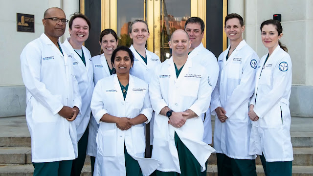 The 2023 WR/USU General Surgery Residency graduating class achieved a 100% first-time board pass rate, marking the third consecutive year for the program. Featured back row left to right: Elliot Jessie, Associate Program Director, chief residents Michael Horsey, Alexis Lauria, Kayleigh Herrick-Reynolds, Pat Benoit, Alec Kersey, and Mary O'Donnell, Associate Program Director. Pictured in the center is chief resident Kal Gunasinha and Capt. (Dr.) Matthew Bradley, Program Director. [Photo courtesy of Capt. (Dr.) Matthew Bradley]