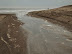 A gulley of water draining out with the tide